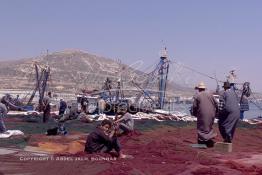 Image du Maroc Professionnelle de  Quelques ouvriers s'activent à réparer les filets de pêche sur un des quais au port d'Agadir, ville située au sud du Maroc, Vendredi 23 Août 2002. (Photo / Abdeljalil Bounhar)

 